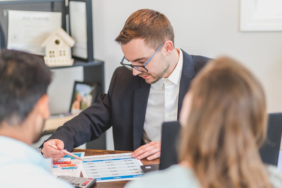 Real estate broker reviewing property listings and transaction status on a dual-monitor workstation