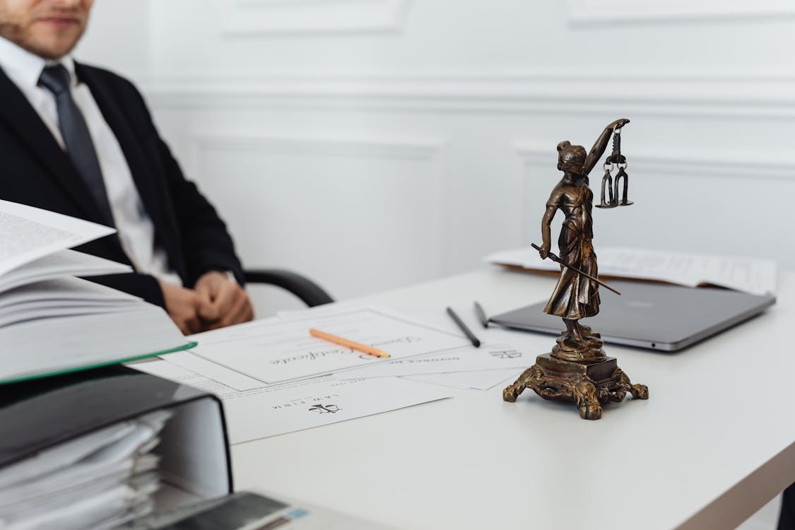 Attorney reviewing case files and notes on a dual-monitor workstation in a law office
